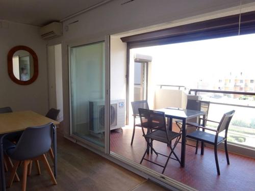 une salle à manger avec une table et des chaises et une fenêtre dans l'établissement Appartement 2 pièces avec terrasse au bord de l'eau, parking, climatisation - FR-1-782-1, au Barcarès