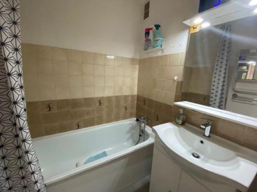 une salle de bain avec une baignoire et un lavabo dans l'établissement Appartement avec terrasse près de la plage - FR-1-782-12, au Barcarès