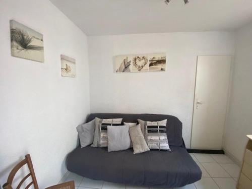 Cette chambre comprend un lit bleu avec des oreillers. dans l'établissement Appartement RDC, 100m plage, 6 pers, terrasse, bbq, parking, TV - FR-1-782-17, au Barcarès