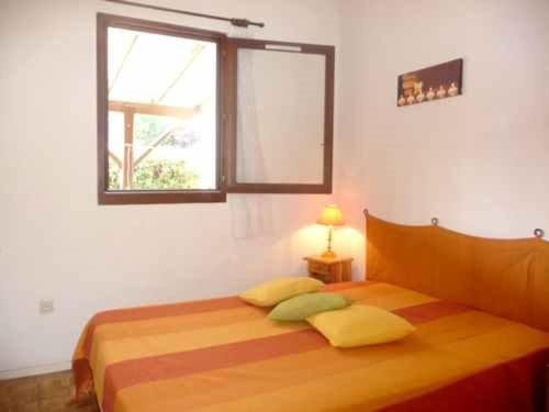 - une chambre avec un lit avec deux oreillers et une fenêtre dans l'établissement Villa T2 avec terrasse, parking et climatisation à 800m de la plage - FR-1-782-11, au Barcarès