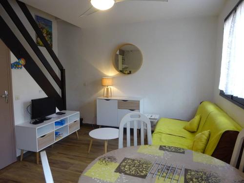 un salon avec un canapé vert et une table dans l'établissement Maison T3 climatisée avec terrasse, parking privé, proche plage et commerces au Barcarès - FR-1-782-6, au Barcarès