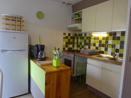 Elle comprend une petite cuisine équipée d'un réfrigérateur blanc et d'un comptoir. dans l'établissement Maison T3 climatisée avec terrasse, parking privé, proche plage et commerces au Barcarès - FR-1-782-6, au Barcarès