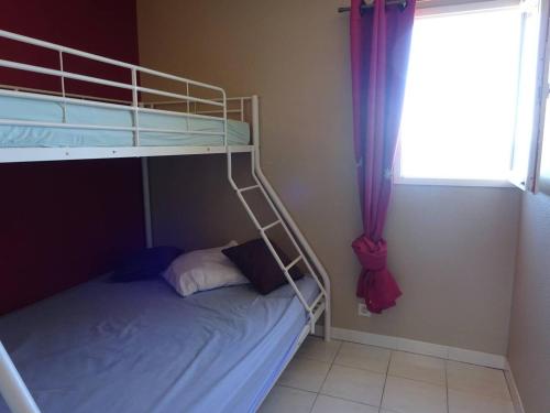 une chambre avec un lit superposé et une fenêtre dans l'établissement Appartement climatisé près de la plage avec parking - 4/5 personnes - FR-1-782-2, au Barcarès