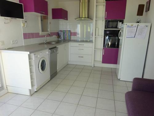 une cuisine avec un réfrigérateur et une machine à laver dans l'établissement Appartement climatisé près de la plage avec parking - 4/5 personnes - FR-1-782-2, au Barcarès