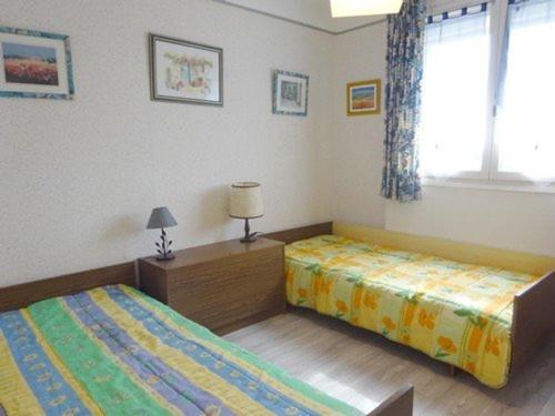 une chambre avec deux lits et une fenêtre dans l'établissement T3 avec terrasse, ascenseur et parking au Barcarès près de la plage - FR-1-782-13, au Barcarès