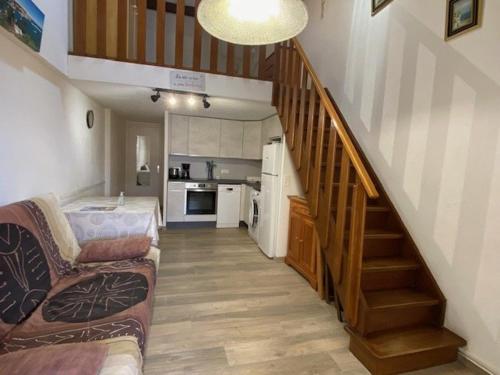 Il comprend un salon avec un escalier doté d'un canapé et une cuisine. dans l'établissement Villa 4 pers, 300m plage, parking, terrasse, BBQ - FR-1-782-25, au Barcarès