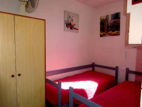 - une petite chambre avec un lit rouge et un placard dans l'établissement Appartement 2 Pièces avec Terrasse, Climatisation, Parking, à 100m de la Plage - Grande Plage - FR-1-782-21, au Barcarès