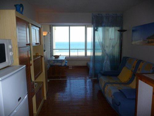 un salon avec un canapé et une vue sur l'océan dans l'établissement Studio à 50m de la plage, parking privé - FR-1-782-23, au Barcarès
