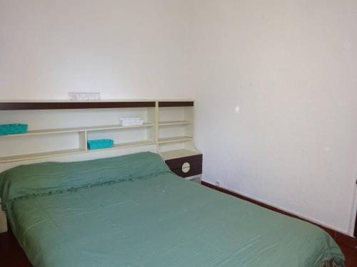 - une petite chambre avec un lit vert dans l'établissement Appartement T2 moderne, près de la plage, terrasse équipée, parking privé - Le Barcarès - FR-1-782-27, au Barcarès