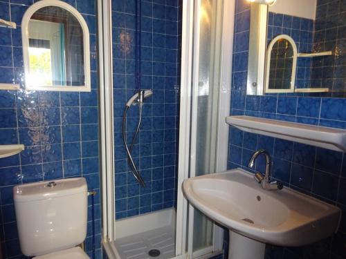 La salle de bains est pourvue de carrelage bleu, de toilettes et d'un lavabo. dans l'établissement Appartement T2 moderne, près de la plage, terrasse équipée, parking privé - Le Barcarès - FR-1-782-27, au Barcarès