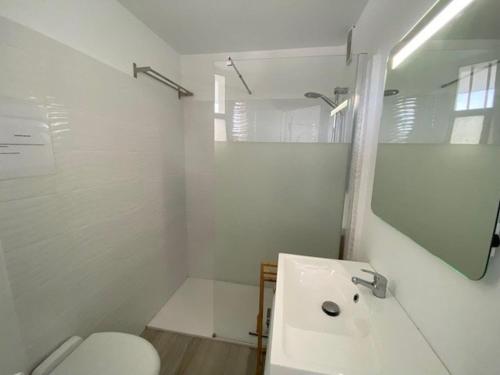 une salle de bain blanche avec un lavabo et des toilettes dans l'établissement Appartement rénové 2P à 100m de la plage avec parking privé - FR-1-782-30, au Barcarès