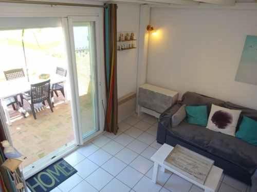 un salon avec un canapé et une porte coulissante en verre dans l'établissement Villa 3 chambres avec parking privé proche plage et commerces - FR-1-782-35, au Barcarès