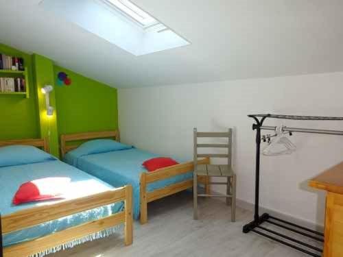 une chambre avec deux lits et une chaise dedans dans l'établissement Villa 3 chambres avec parking privé proche plage et commerces - FR-1-782-35, au Barcarès