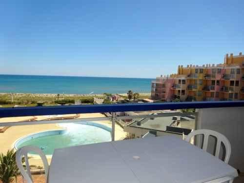 un balcon avec vue sur une piscine et l'océan dans l'établissement Appartement 2/3 pièces avec piscine, tennis et parking privé, proche commerces - FR-1-782-43, au Barcarès