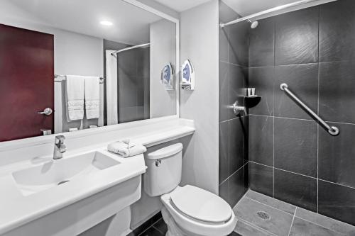La salle de bains est pourvue de toilettes, d'un lavabo et d'une douche. dans l'établissement City Express by Marriott Leon, à León