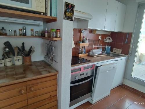 une cuisine avec une cuisinière et un comptoir dans l'établissement Appartement 5 personnes avec terrasse, parking, WIFI et accès direct à la plage - FR-1-776-86, à Canet