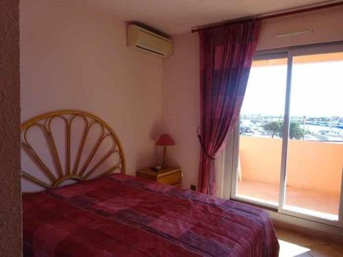 une chambre avec un lit et une grande fenêtre dans l'établissement Appartement climatisé avec terrasse et parking à 100m de la plage - FR-1-782-45, au Barcarès