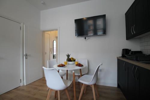 a kitchen with a white table and white chairs at Superb Flat - Pet Friendly - Free Parking Dundee in Dundee