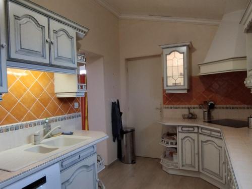 a kitchen with white cabinets and a sink at Maison Saint-Georges-d'Oléron, 5 pièces, 8 personnes - FR-1-778-19 in Saint-Georges-dʼOléron