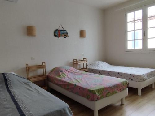 - une chambre avec 2 lits et un van sur le mur dans l'établissement Grande maison familiale, 9 pers., à 1800m de la plage, avec terrasses, clim, et équipements complets - FR-1-778-19, à Saint-Georges-dʼOléron