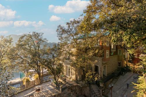 a building with a fence in front of it at SaffronStays Naiintara in Nainital