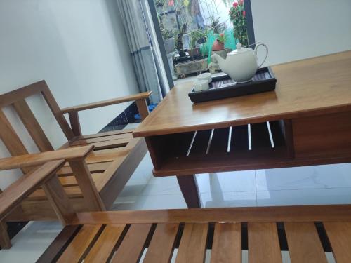 une table en bois avec une chaise et un vase. dans l'établissement NEW WAVE HOMESTAY, à Ấp Khánh Phước (1)