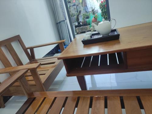 a wooden table with a chair and a vase on it at NEW WAVE HOMESTAY in Ấp Khánh Phước (1)