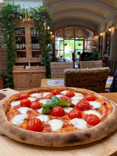 a pizza with tomatoes on top of a table at Pensiunea Gasthaus Alte Post in Sighişoara