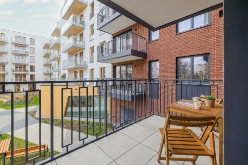 een balkon met een tafel en stoelen in een gebouw bij Cozy Apartment Orawska with Balcony by Renters in Krakau