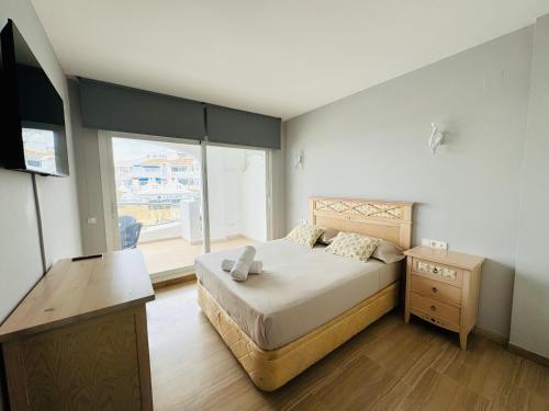 - une chambre avec un grand lit et une fenêtre dans l'établissement G&G Isla Marina Puerto 2, à Benalmádena