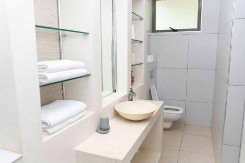biała łazienka z umywalką i toaletą w obiekcie The Four Palms w mieście Kilifi