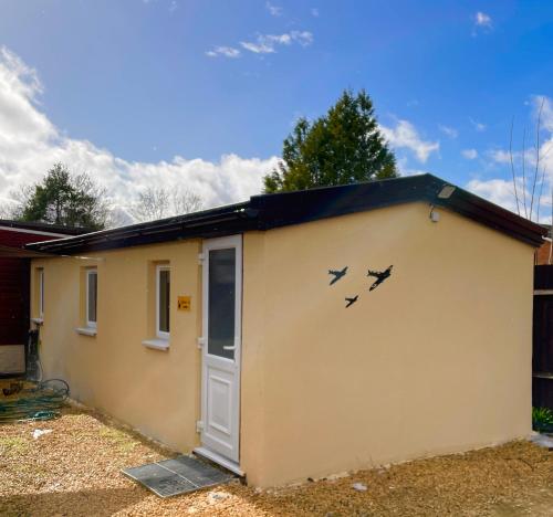 two birds painted on the side of a garage at Heathrow Airport 10 mins drive l FREE SECURE PARKING l Tiny House with Courtyard in New Bedfont
