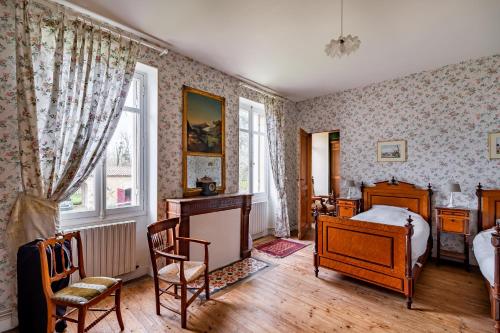 a bedroom with a bed and a table and chairs at Sorbède - Charmante maison pour 10 personnes in Montussan