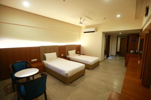 海得拉巴的住宿－HOTEL SHUBHAM PALACE，酒店客房设有两张床和一张桌子。
