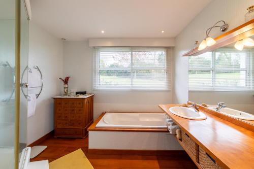 La salle de bains est pourvue d'une baignoire et d'un grand lavabo. dans l'établissement Les Vignes - 4 chambres piscine et grand jardin, à Villeneuve-sur-Lot