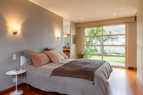 une chambre avec un grand lit et une grande fenêtre dans l'établissement Les Vignes - 4 chambres piscine et grand jardin, à Villeneuve-sur-Lot
