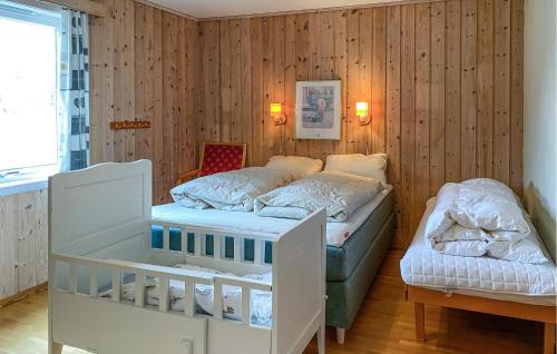 een slaapkamer met 2 bedden en een wieg bij Beautiful Apartment In Eidsvg I Romsdal With Wifi 