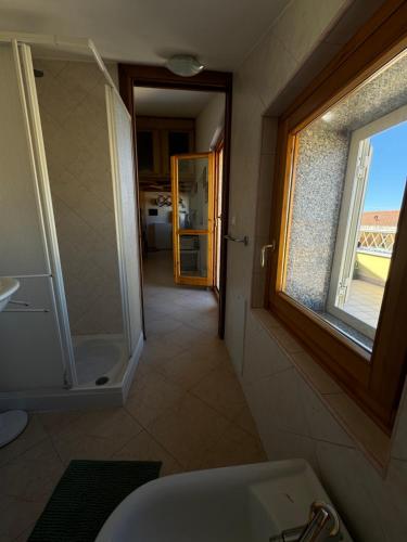 a bathroom with a shower and a sink and a window at PM 6 Via Giovanni Giolitti Guest House in Alghero