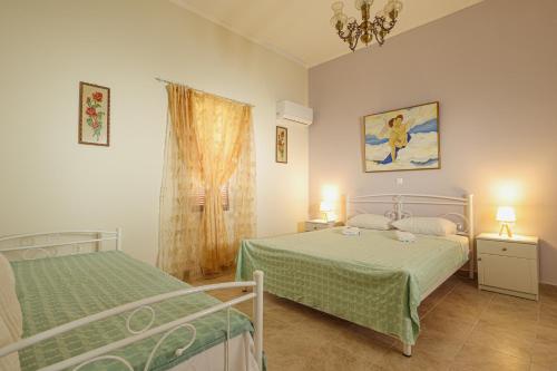 a bedroom with two beds and a chandelier at Aneza in Kremasti