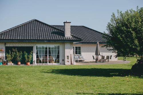a house with a patio and an umbrella in the yard at Bungalow mit Basketballplatz in Lemgo