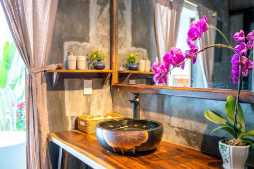 a bathroom with a sink and flowers on a counter at Garden of Love Villa in An Bang, Hoi An in An Bang