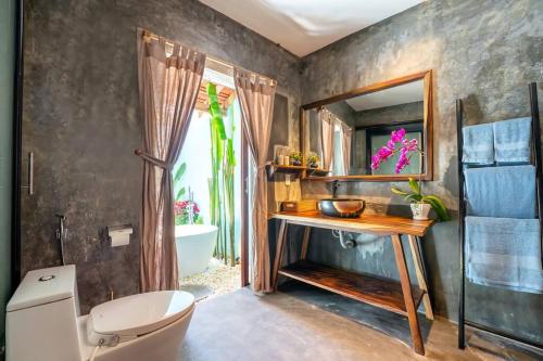 a bathroom with a sink and a toilet and a mirror at Garden of Love Villa in An Bang, Hoi An in An Bang
