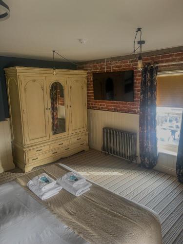 a bedroom with a bed with two towels on it at The White Horse Hotel in Leiston