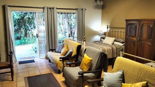 a bedroom with a bed and a bed and chairs at Anri Guesthouse in Bloemfontein