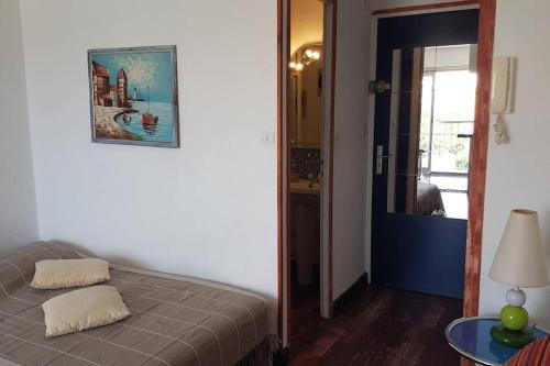 une chambre avec un lit avec un tableau sur le mur dans l'établissement Studio-2 Personnes-Résidence Le Pharo, Vue Piscine Port, au Cap d'Agde