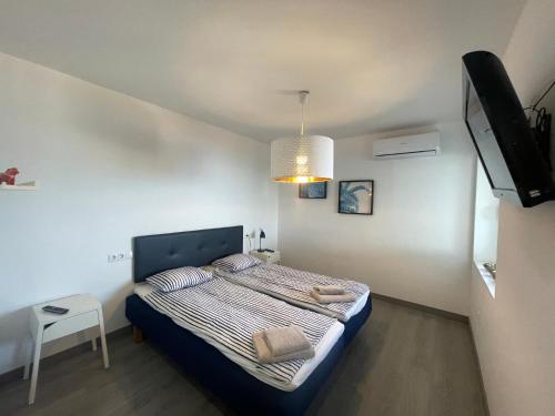 ein kleines Schlafzimmer mit einem Bett und einem TV in der Unterkunft Apartamento en urbanización con fantásticas vistas in Benalmádena