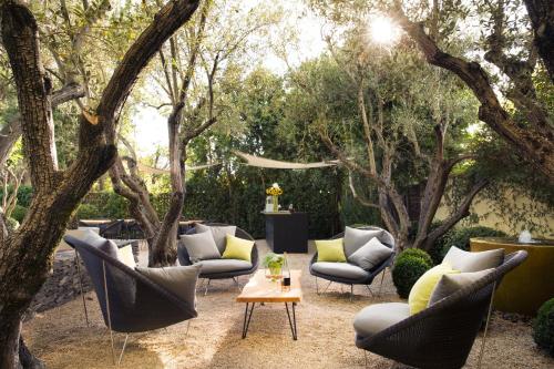 a patio with chairs and a table and trees at Hotel Healdsburg in Healdsburg