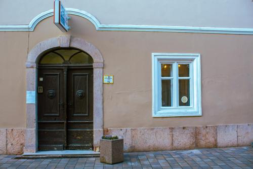 a building with a black door and a window at Lima Mini - cozy apartment - in Győr