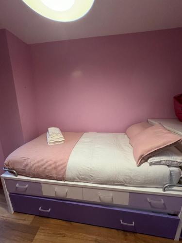 a bed in a room with a purple wall at Apartamento La Boira in Broto
