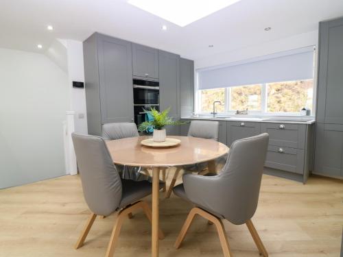 a kitchen with a wooden table and gray chairs at Craignure in Banff